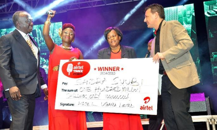 Airtel Uganda COO Diego Javier hands a cheque to Sandra Suubi, local winner of Airtel Trace Music Star, and her family.