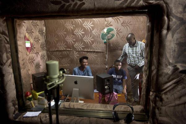 Students talk to school Director Jean Claude Nkulikiyimfura as they practice in the music recording studio Source:www.m.deser