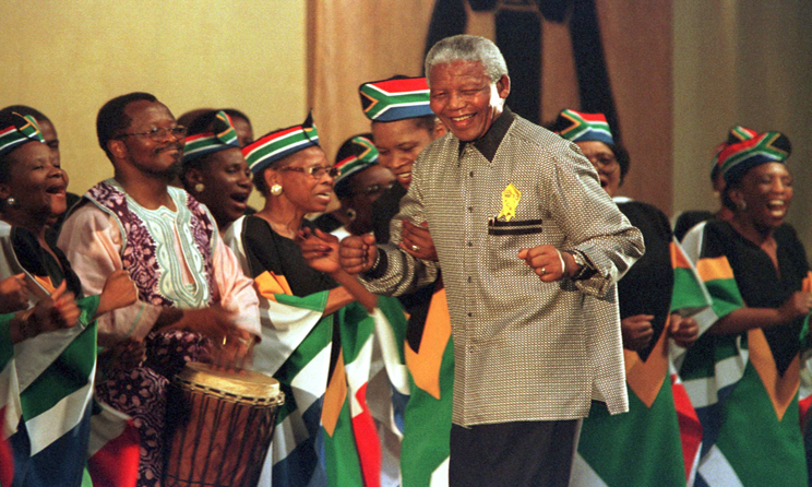Nelson Mandela dances with a South African choir in Harare, Zimbabwe, in December 1998.
