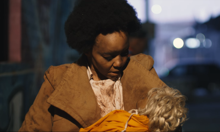 An emotionally disturbed Cici cradling a baby doll in 'Ngidinge'.