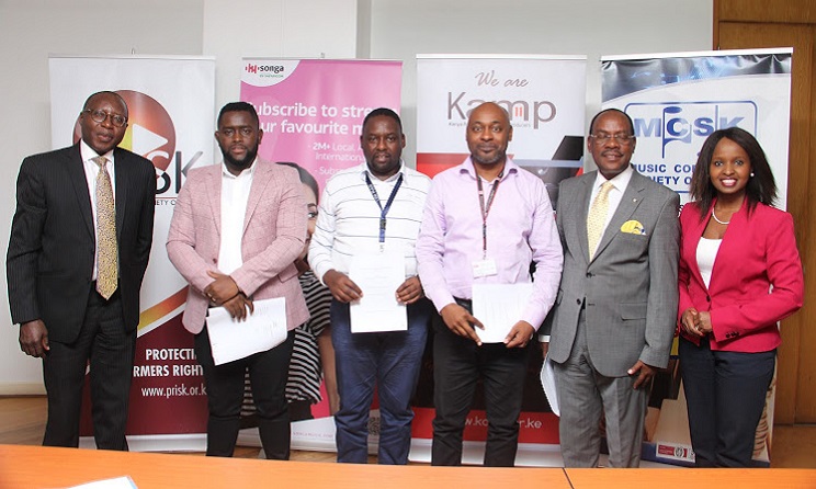 Radio Africa group CEO Patrick Quarcoo, PRISK chairperson Ephantus Wahome, KAMP chairperson Anthony Karani, Songa general manager Chinasa Udeala, MCSK chairperson Japeth Kassanga and KAMP vice-chairperson Angela Ndambuki pose for a photo after signing the agreement. Photo: Ezekiel Aming'a