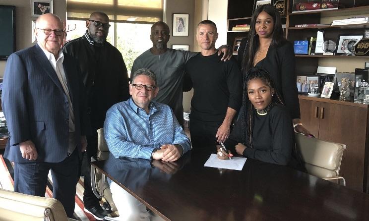 Nigerian musician Tiwa Savage sits next to Universal CEO Sir Lucian Grainge during the signing of her contract with the multinational record label in 2019.