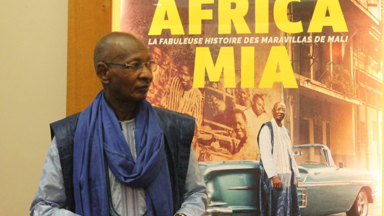 Le musicien Boncana Maïga devant l'affiche d'« Africa Mia » (Photo) : gnakrylive.com