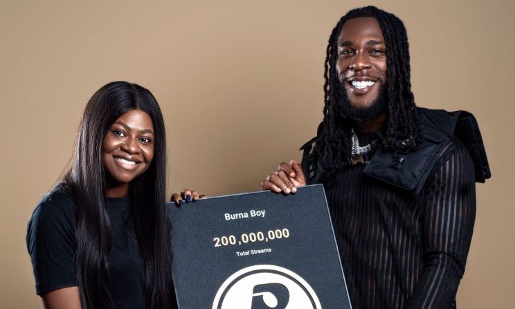 Boomplay’s Tosin Sorinola presenting Burna Boy with a plaque in recognition of his latest milestone.