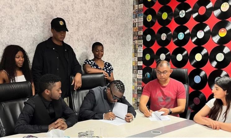 Rayvanny (middle) during the signing of his agreement with Mziiki.